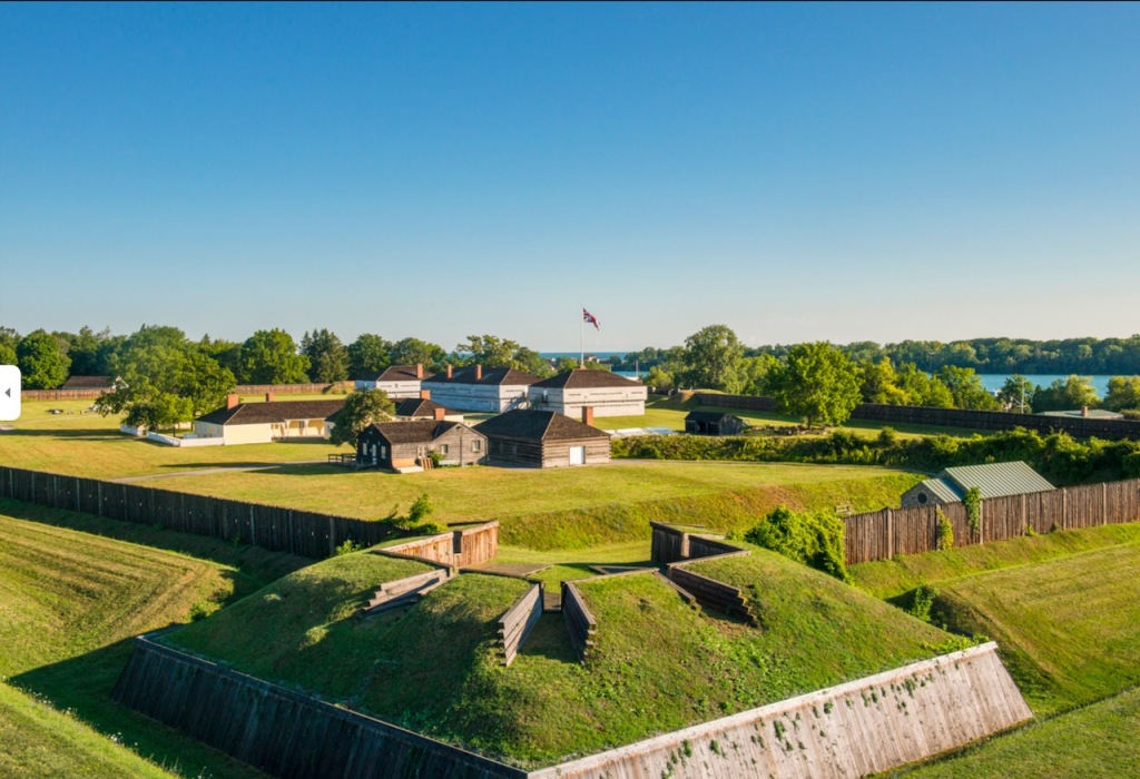 Aerial view of Fort George with barracks and protective fences and a view of the niagara River